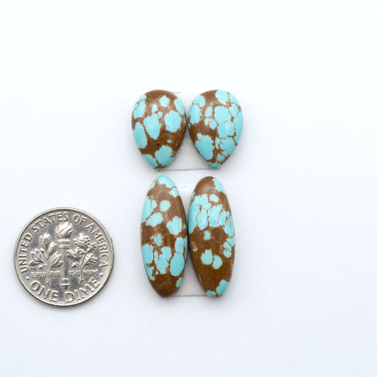 Number 8 Turquoise cabochons, blue and green color with brown matrix, polished stones on a white background, with a US dime for scale