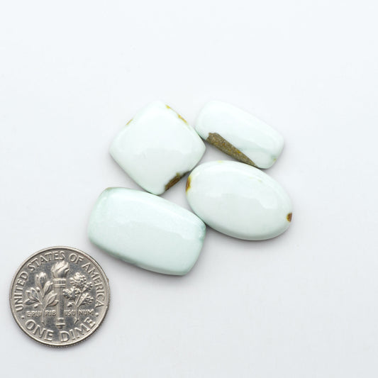 Palomino Variscite cabochons, polished yellow-green gemstones with natural matrix on a white background with a US dime for scale