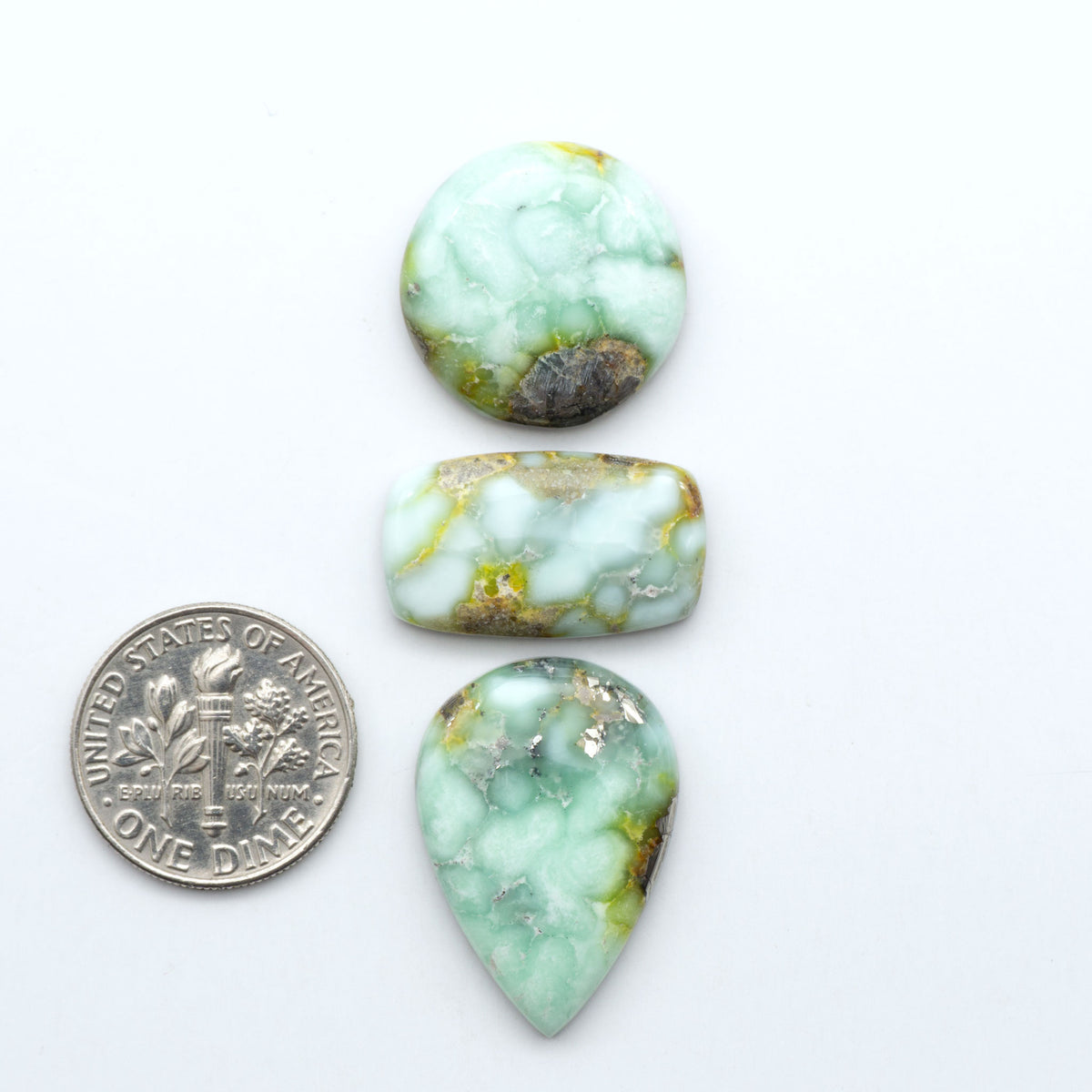 Palomino Variscite cabochons, polished yellow-green gemstones with natural matrix on a white background with a US dime for scale
