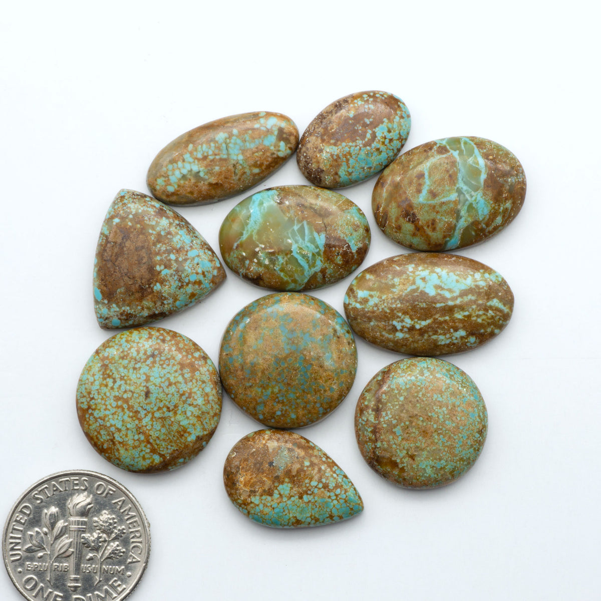 Number 8 Turquoise cabochons, blue and green color with brown matrix, polished stones on a white background, with a US dime for scale
