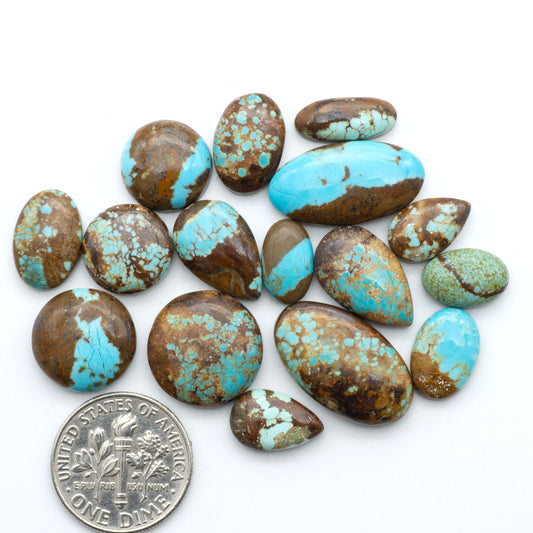 Number 8 Turquoise cabochons, blue and green color with brown matrix, polished stones on a white background, with a US dime for scale