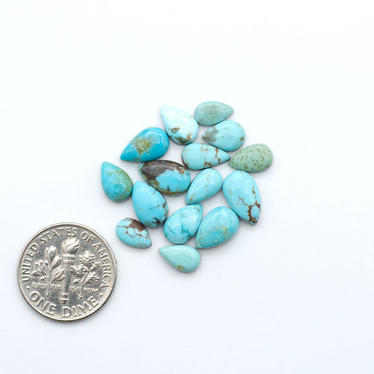 Number 8 Turquoise cabochons, blue and green color with brown matrix, polished stones on a white background, with a US dime for scale