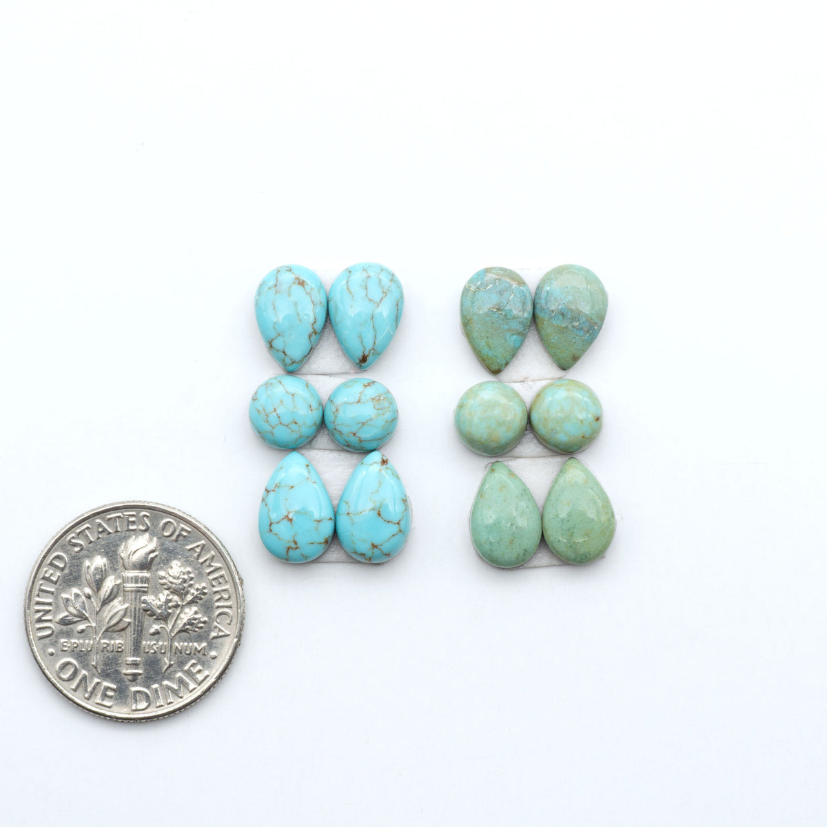 Number 8 Turquoise cabochons, blue and green color with brown matrix, polished stones on a white background, with a US dime for scale