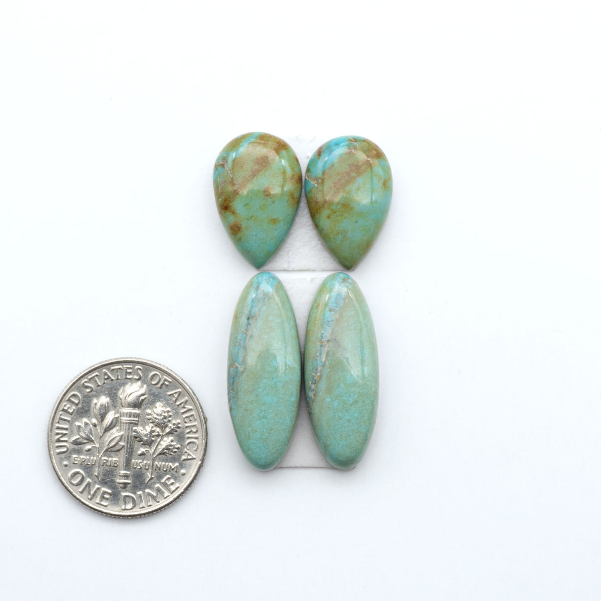 Number 8 Turquoise cabochons, blue and green color with brown matrix, polished stones on a white background, with a US dime for scale