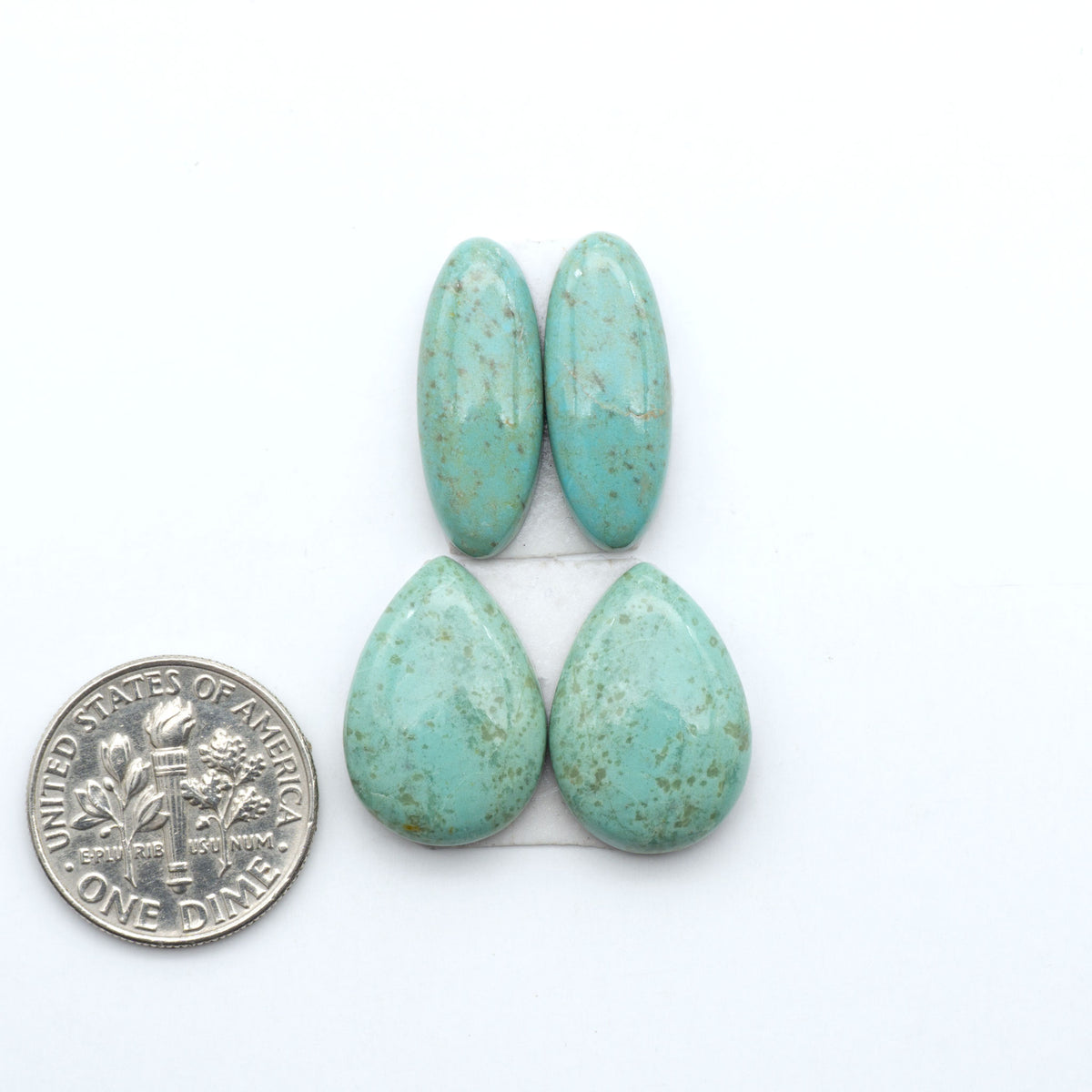Number 8 Turquoise cabochons, blue and green color with brown matrix, polished stones on a white background, with a US dime for scale