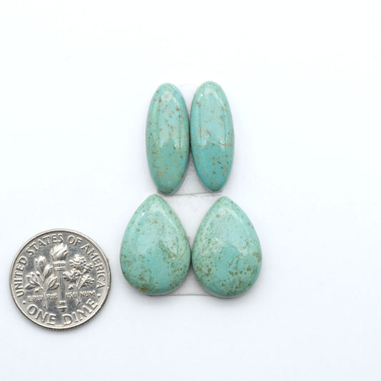 Number 8 Turquoise cabochons, blue and green color with brown matrix, polished stones on a white background, with a US dime for scale