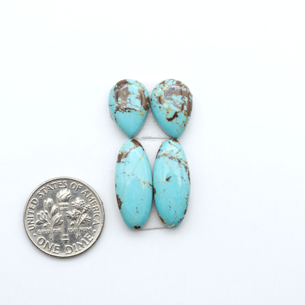 Number 8 Turquoise cabochons, blue and green color with brown matrix, polished stones on a white background, with a US dime for scale