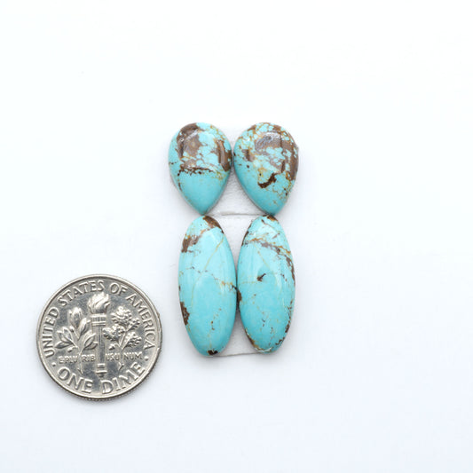 Number 8 Turquoise cabochons, blue and green color with brown matrix, polished stones on a white background, with a US dime for scale