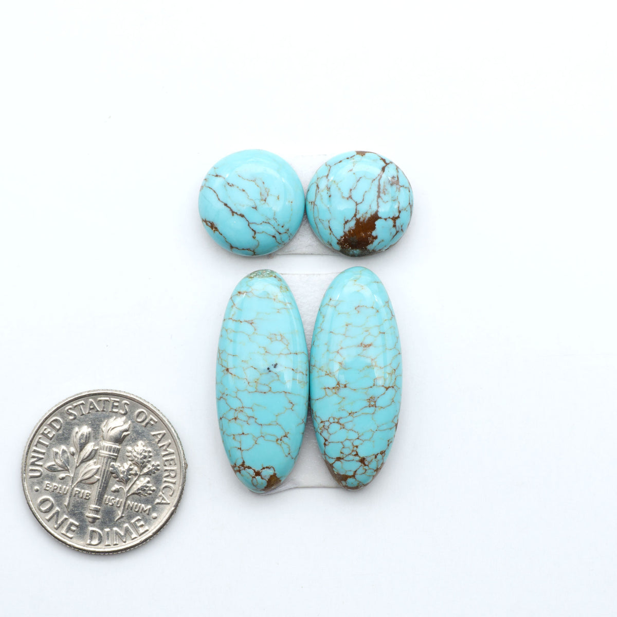 Number 8 Turquoise cabochons, blue and green color with brown matrix, polished stones on a white background, with a US dime for scale