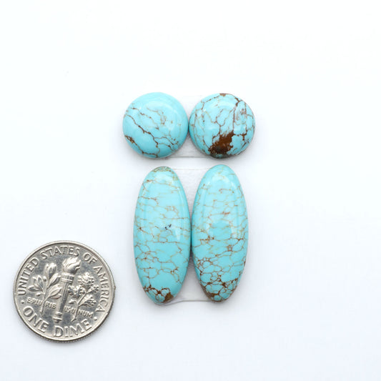 Number 8 Turquoise cabochons, blue and green color with brown matrix, polished stones on a white background, with a US dime for scale