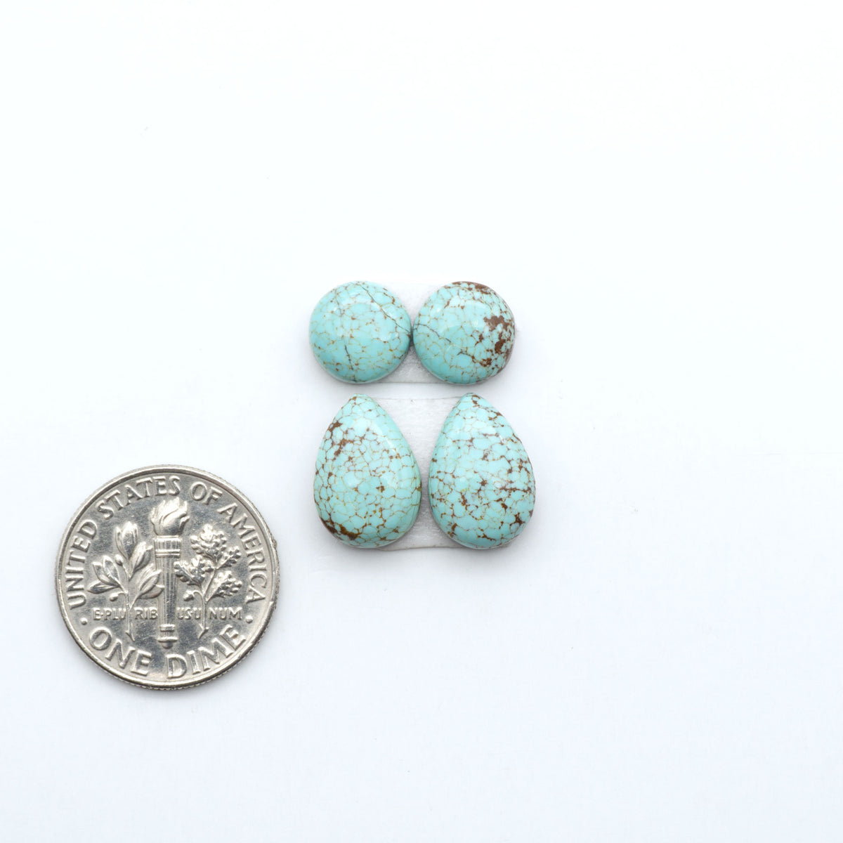 Number 8 Turquoise cabochons, blue and green color with brown matrix, polished stones on a white background, with a US dime for scale
