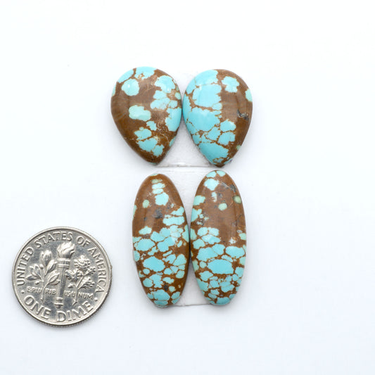 Number 8 Turquoise cabochons, blue and green color with brown matrix, polished stones on a white background, with a US dime for scale