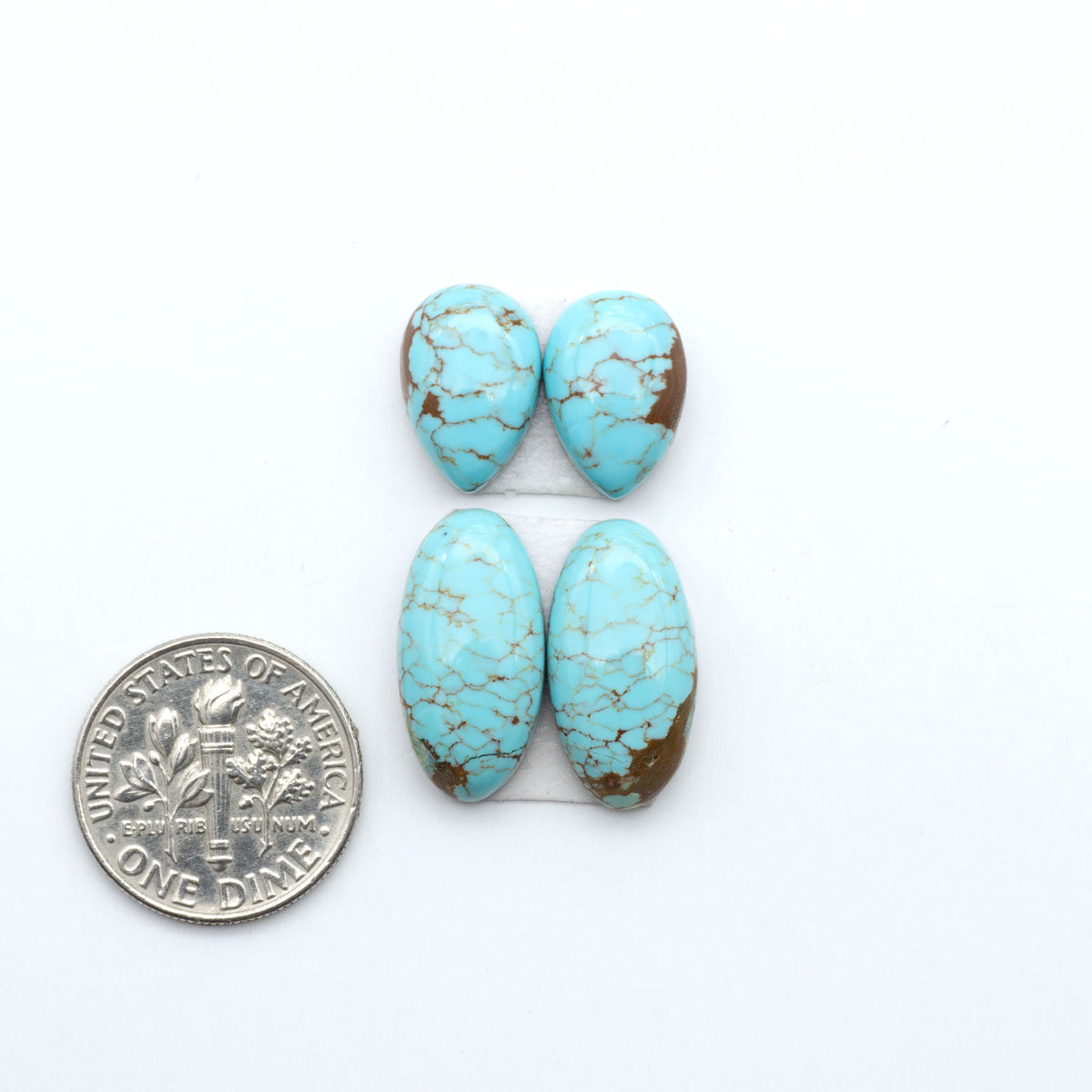 Number 8 Turquoise cabochons, blue and green color with brown matrix, polished stones on a white background, with a US dime for scale