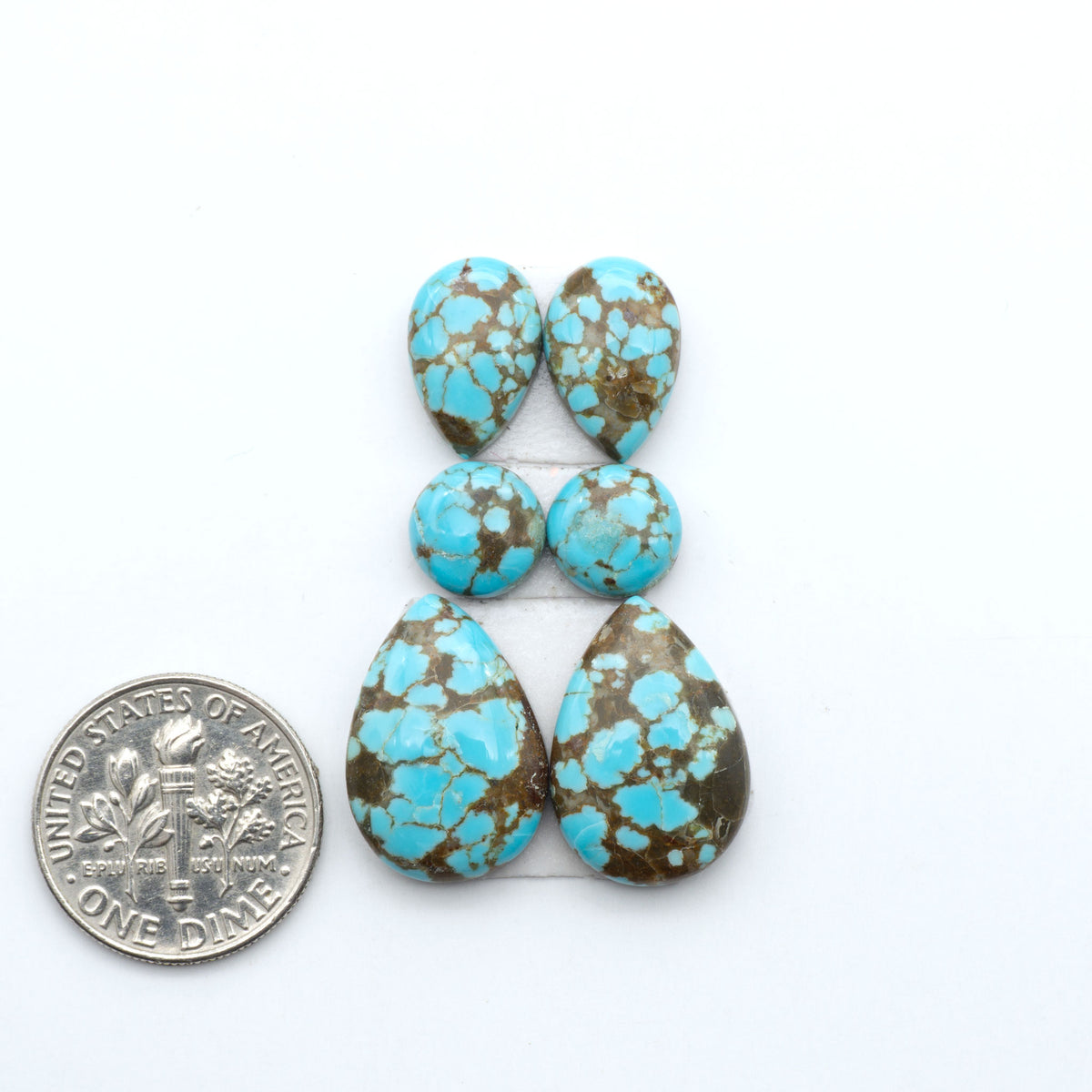 Number 8 Turquoise cabochons, blue and green color with brown matrix, polished stones on a white background, with a US dime for scale