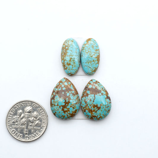 Number 8 Turquoise cabochons, blue and green color with brown matrix, polished stones on a white background, with a US dime for scale