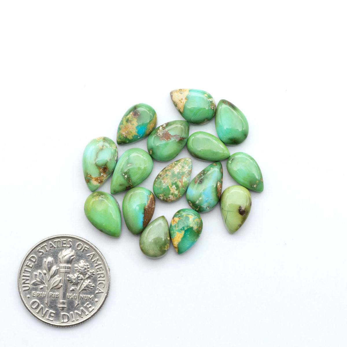 Sonoran Mountain Turquoise cabochons, blue-green color with natural matrix, polished stones on a white background, with a US dime for scale