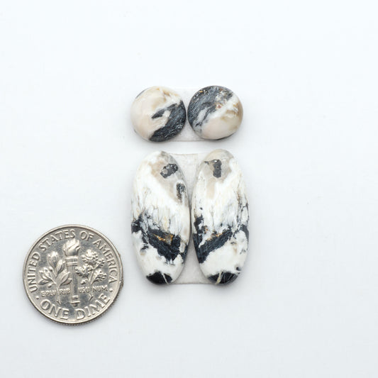 White Buffalo stone cabochons, white stone with black matrix, polished stones on a white background, with a US dime for scale
