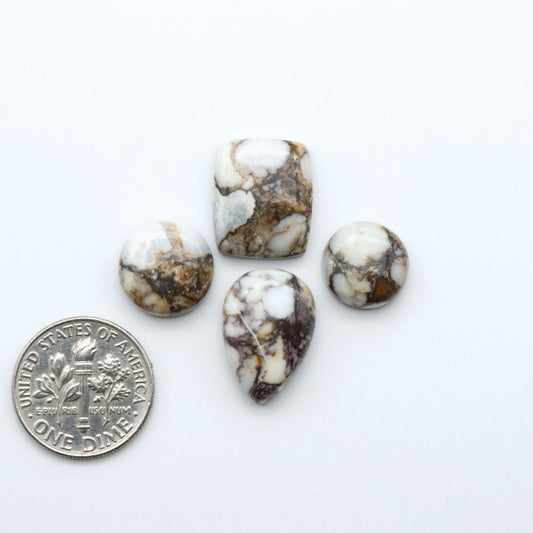 Wild Horse Magnesite cabochons, white gemstones with brown matrix on a white background, with a US dime for scale