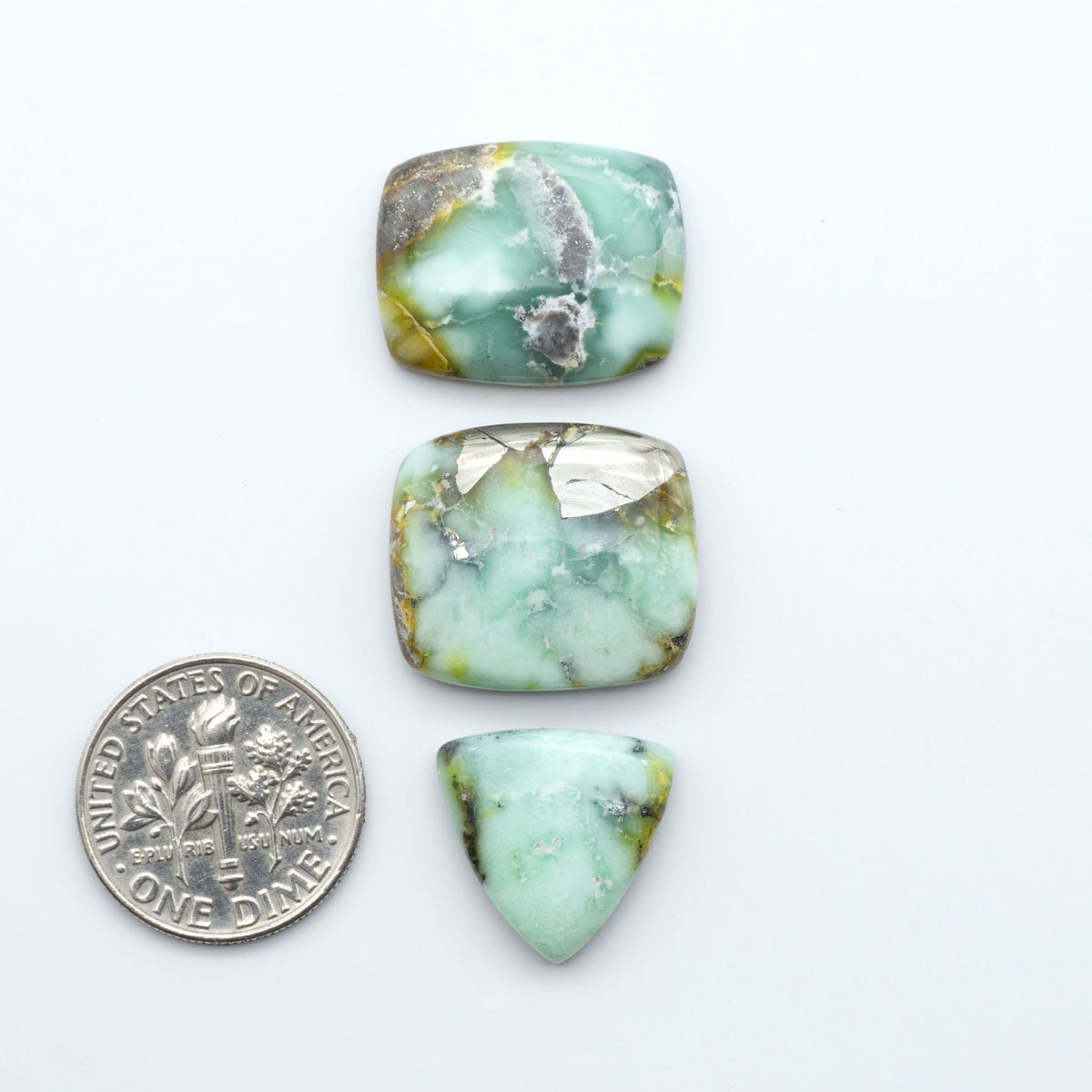 Palomino Variscite cabochons, polished yellow-green gemstones with natural matrix on a white background with a US dime for scale