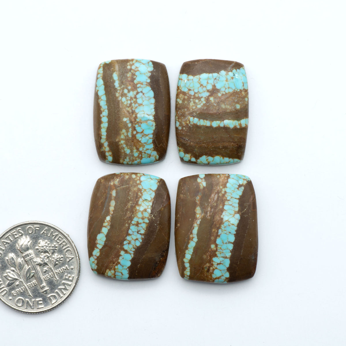 Number 8 Turquoise cabochons, blue and green color with brown matrix, polished stones on a white background, with a US dime for scale