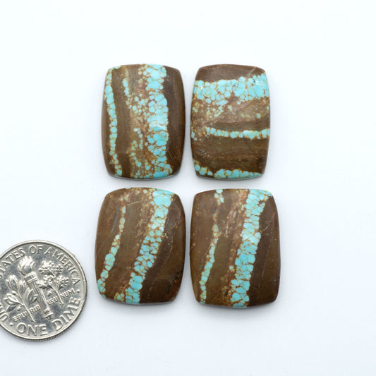Number 8 Turquoise cabochons, blue and green color with brown matrix, polished stones on a white background, with a US dime for scale