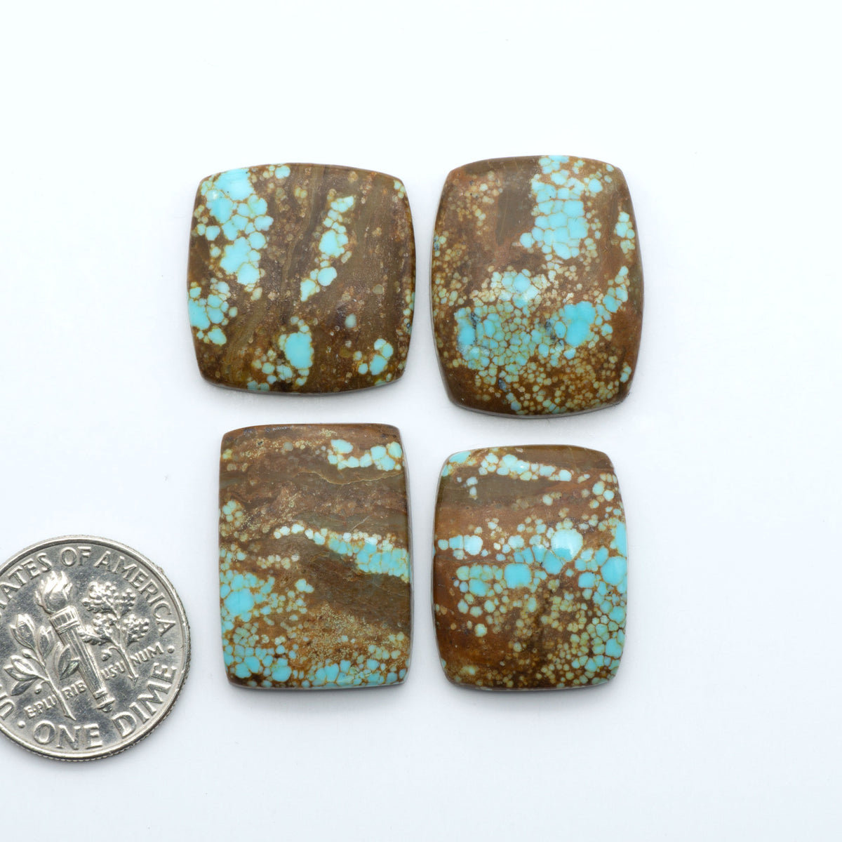 Number 8 Turquoise cabochons, blue and green color with brown matrix, polished stones on a white background, with a US dime for scale