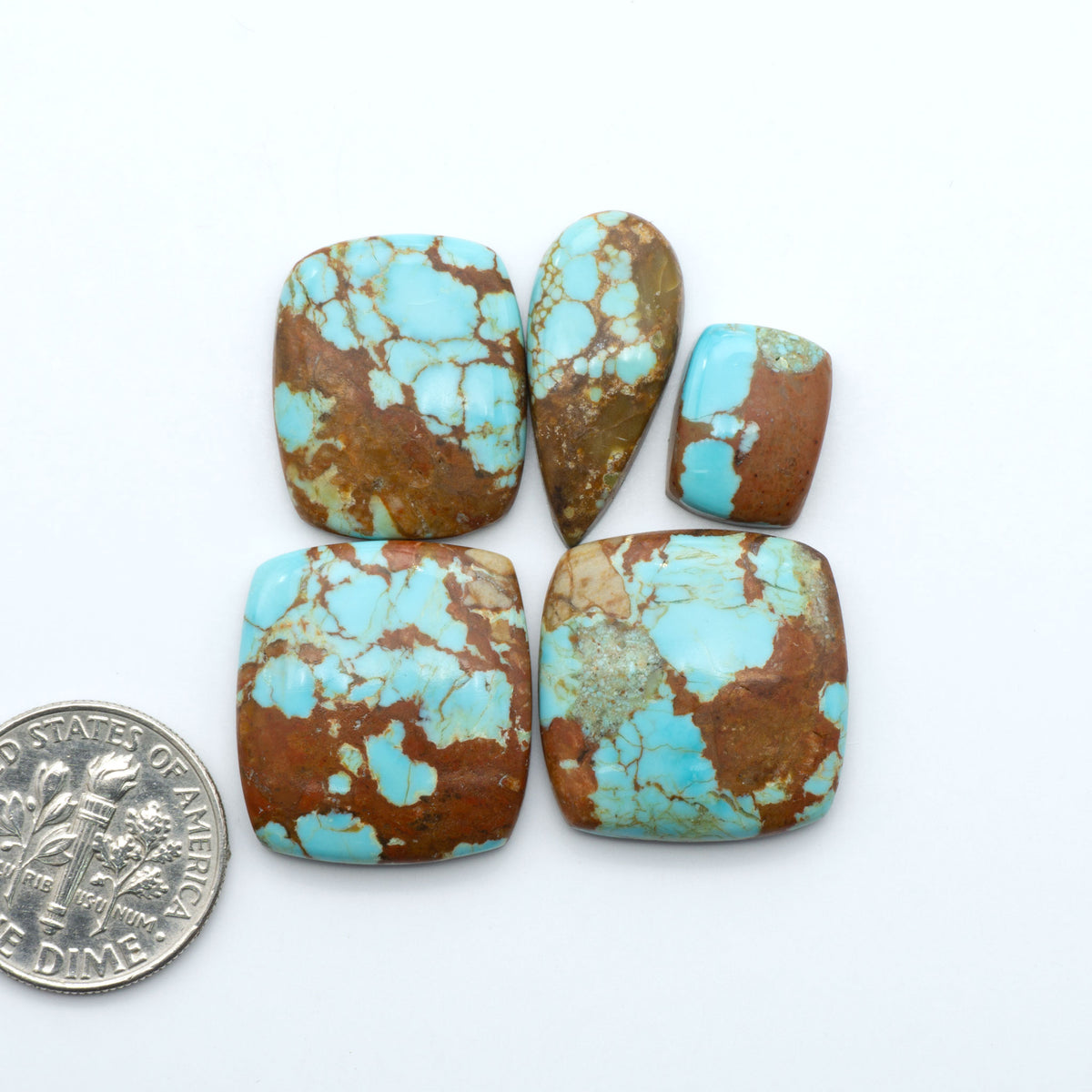 Number 8 Turquoise cabochons, blue and green color with brown matrix, polished stones on a white background, with a US dime for scale