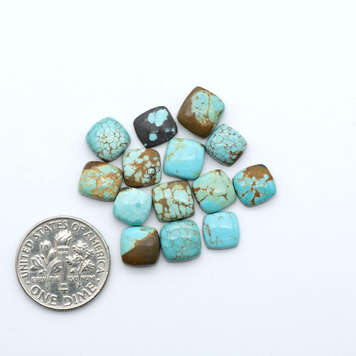 Number 8 Turquoise cabochons, blue and green color with brown matrix, polished stones on a white background, with a US dime for scale