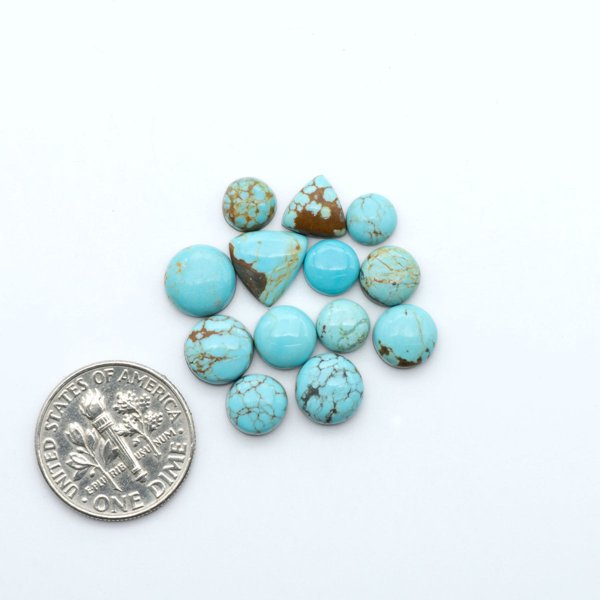 Number 8 Turquoise cabochons, blue and green color with brown matrix, polished stones on a white background, with a US dime for scale