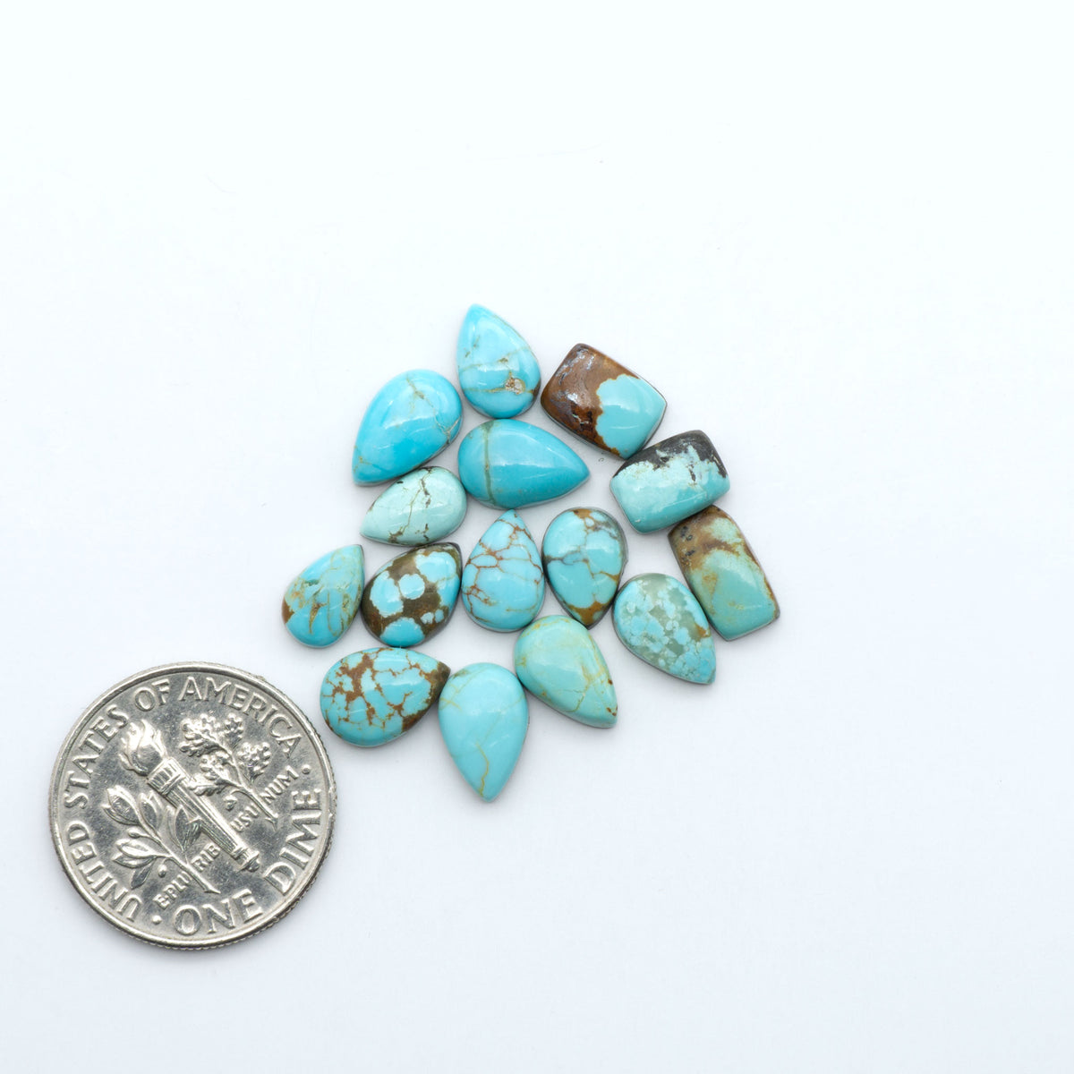 Number 8 Turquoise cabochons, blue and green color with brown matrix, polished stones on a white background, with a US dime for scale