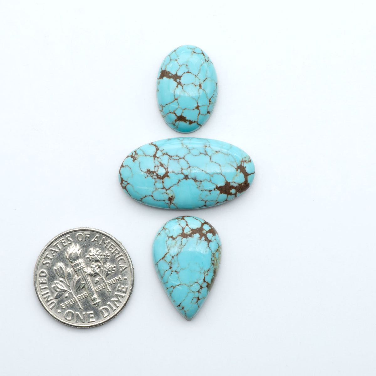 Number 8 Turquoise cabochons, blue and green color with brown matrix, polished stones on a white background, with a US dime for scale