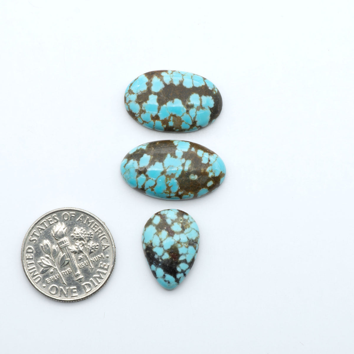 Number 8 Turquoise cabochons, blue and green color with brown matrix, polished stones on a white background, with a US dime for scale