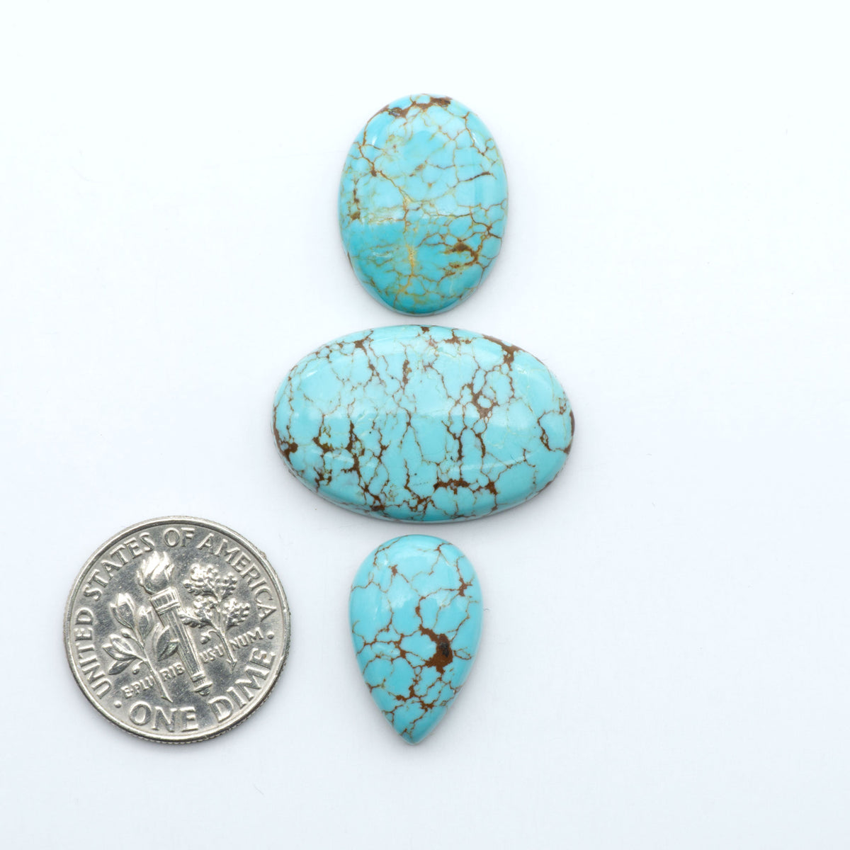 Number 8 Turquoise cabochons, blue and green color with brown matrix, polished stones on a white background, with a US dime for scale
