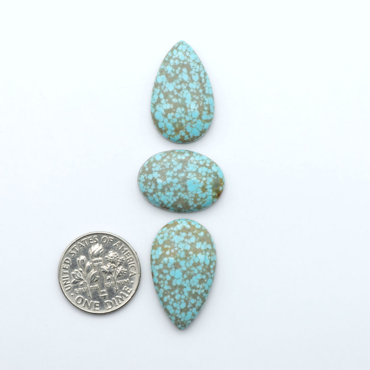 Number 8 Turquoise cabochons, blue and green color with brown matrix, polished stones on a white background, with a US dime for scale