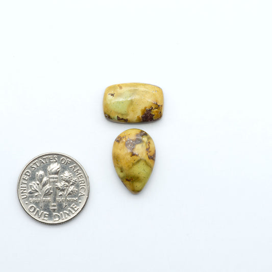Golden Hills Turquoise cabochons, icy blue to lavender tones with chocolate matrix, polished stones on a white background with a US dime for scale