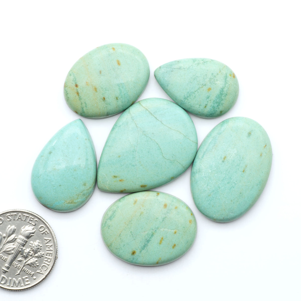 Number 8 Turquoise cabochons, blue and green color with brown matrix, polished stones on a white background, with a US dime for scale