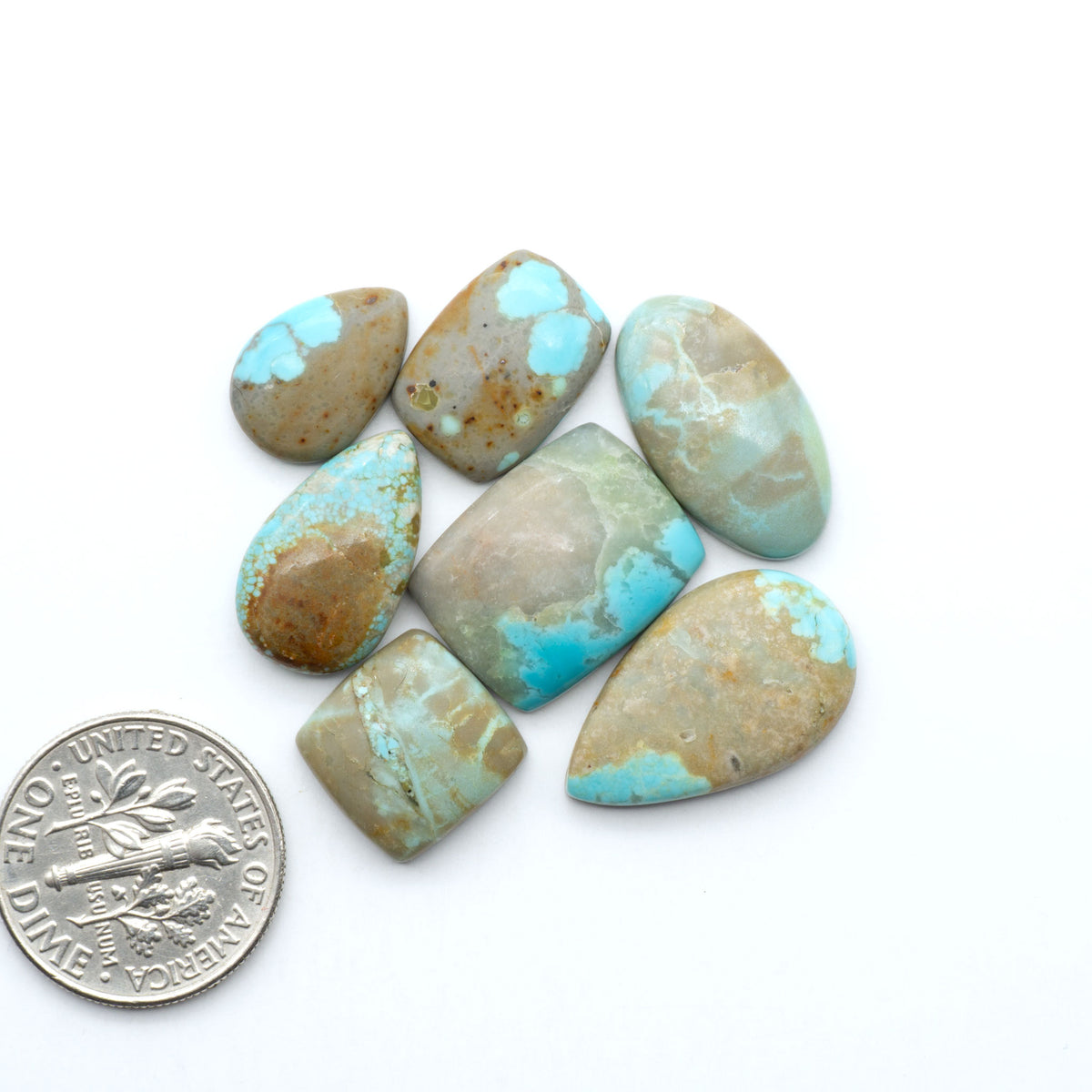 Number 8 Turquoise cabochons, blue and green color with brown matrix, polished stones on a white background, with a US dime for scale