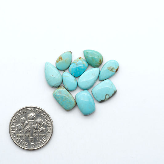 Number 8 Turquoise cabochons, blue and green color with brown matrix, polished stones on a white background, with a US dime for scale