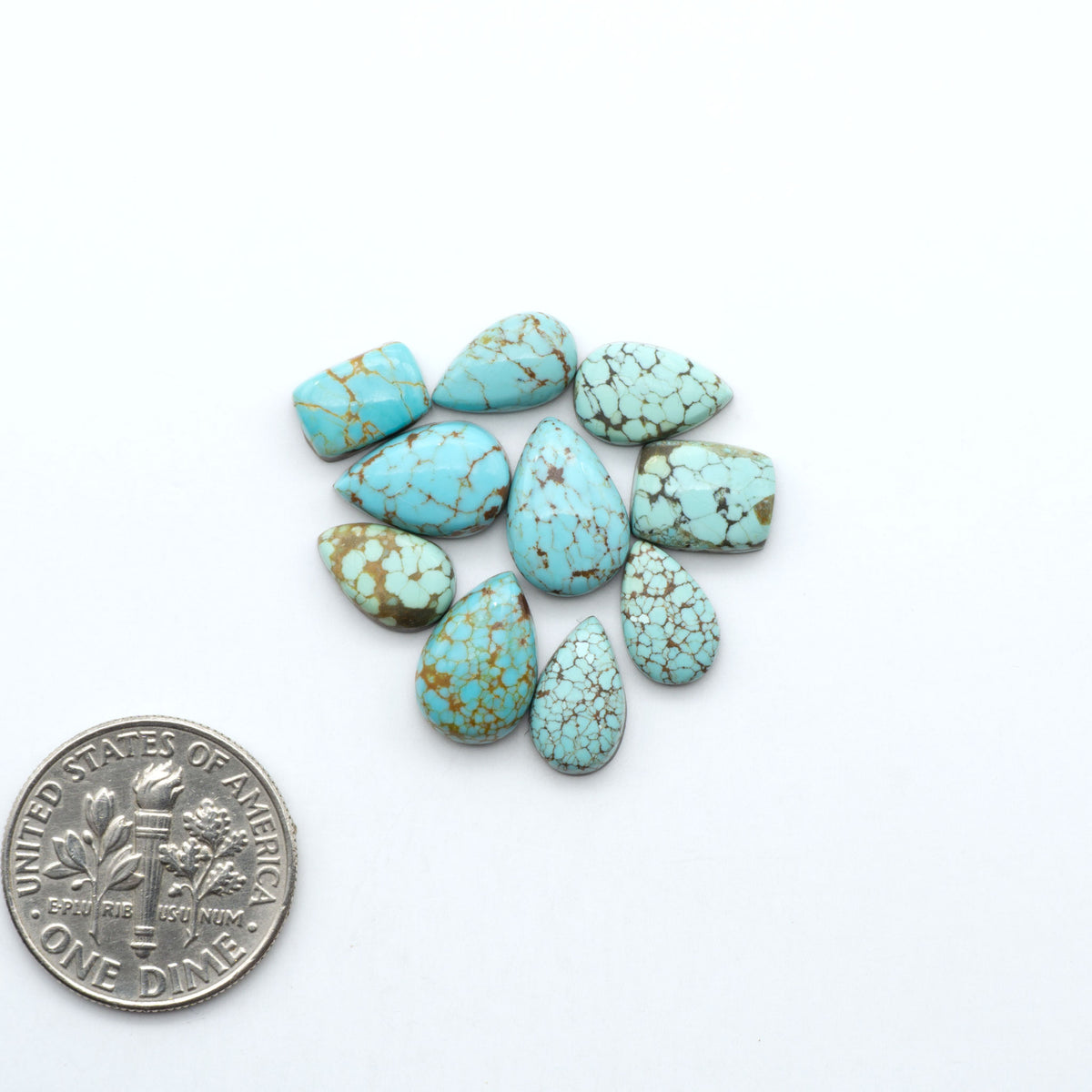 Number 8 Turquoise cabochons, blue and green color with brown matrix, polished stones on a white background, with a US dime for scale