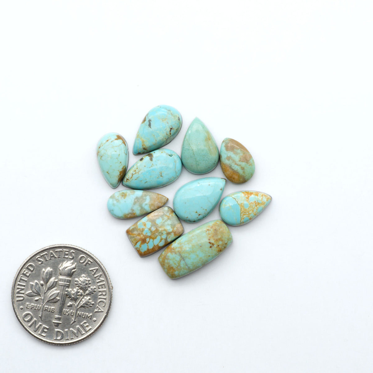 Number 8 Turquoise cabochons, blue and green color with brown matrix, polished stones on a white background, with a US dime for scale