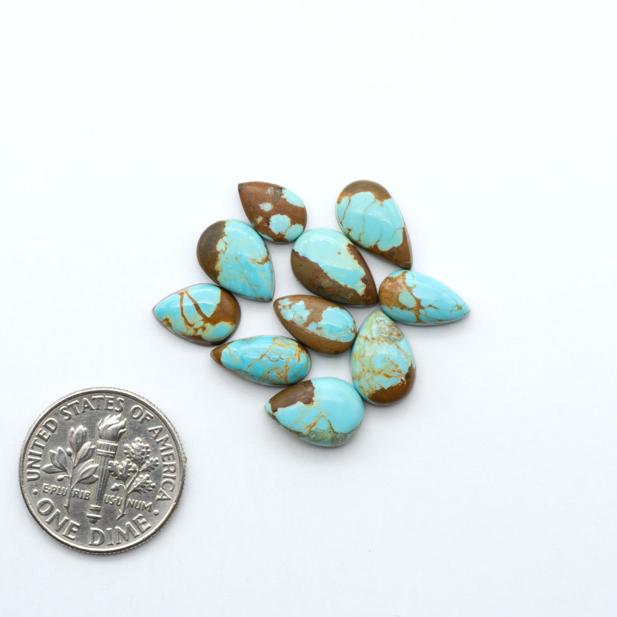 Number 8 Turquoise cabochons, blue and green color with brown matrix, polished stones on a white background, with a US dime for scale