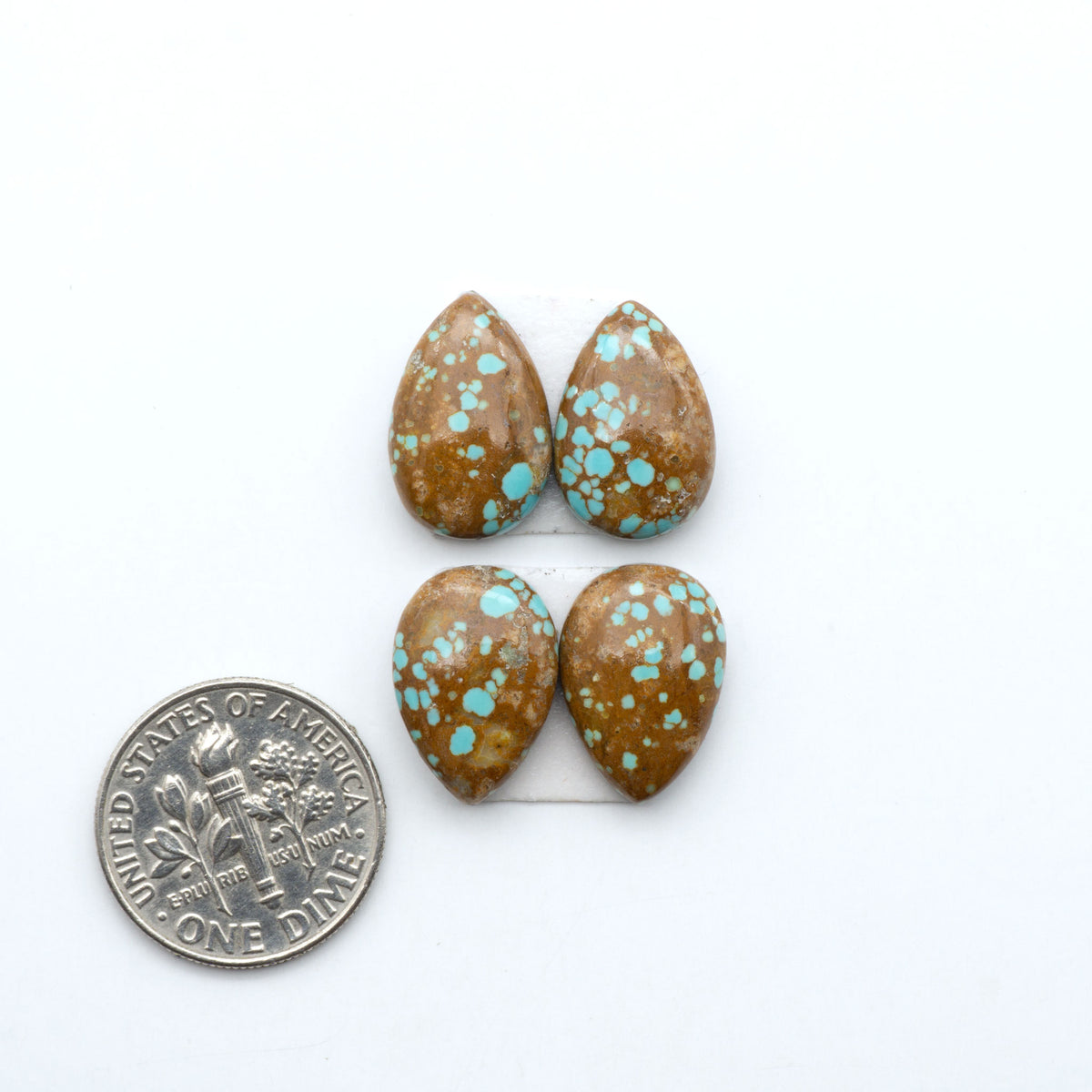 Number 8 Turquoise cabochons, blue and green color with brown matrix, polished stones on a white background, with a US dime for scale