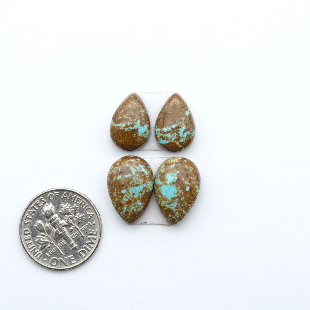 Number 8 Turquoise cabochons, blue and green color with brown matrix, polished stones on a white background, with a US dime for scale