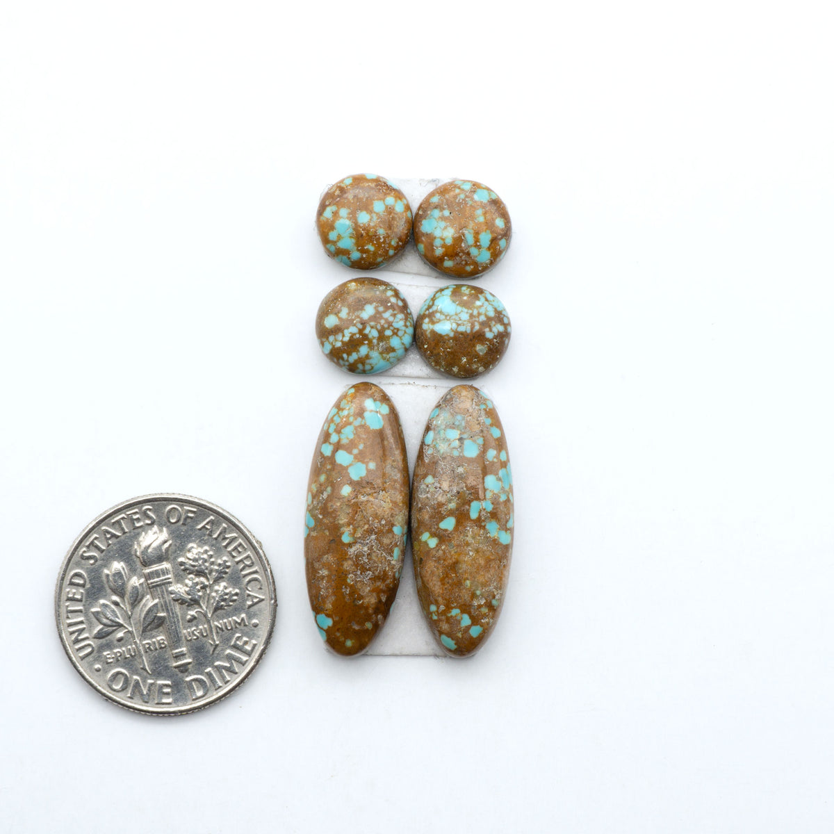 Number 8 Turquoise cabochons, blue and green color with brown matrix, polished stones on a white background, with a US dime for scale