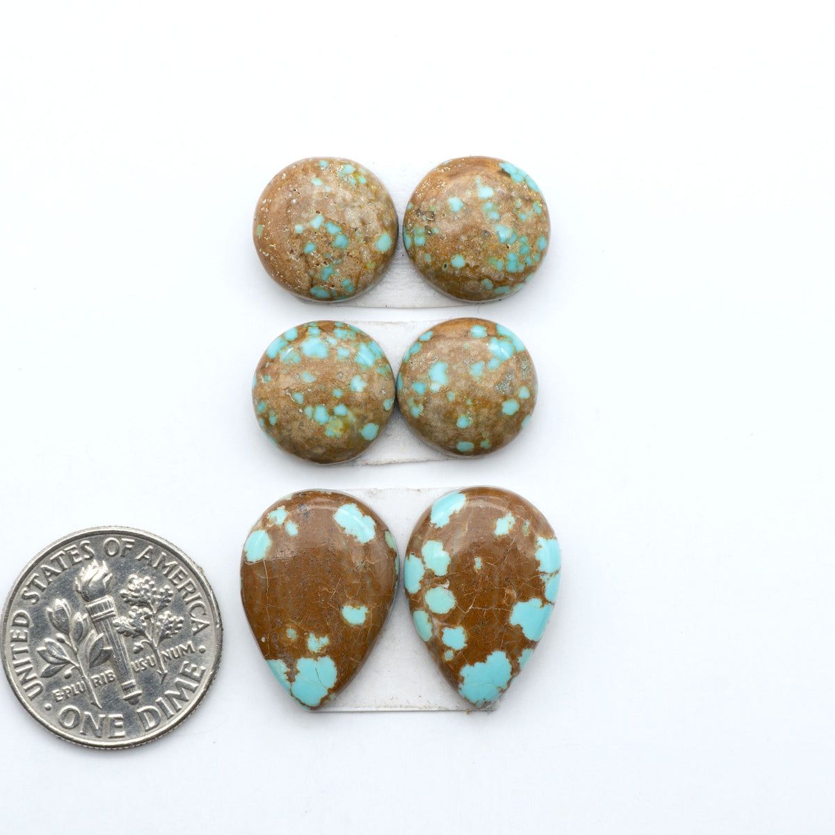 Number 8 Turquoise cabochons, blue and green color with brown matrix, polished stones on a white background, with a US dime for scale