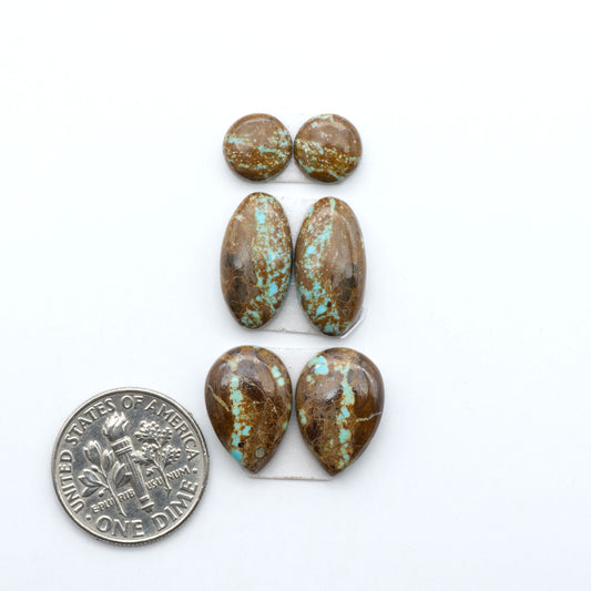 Number 8 Turquoise cabochons, blue and green color with brown matrix, polished stones on a white background, with a US dime for scale