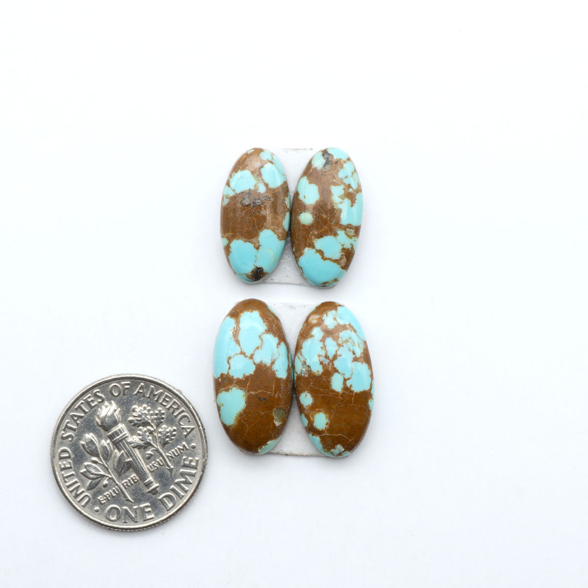 Number 8 Turquoise cabochons, blue and green color with brown matrix, polished stones on a white background, with a US dime for scale
