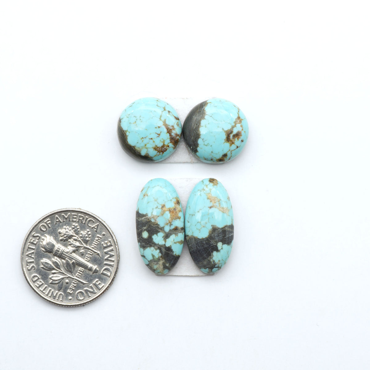 Number 8 Turquoise cabochons, blue and green color with brown matrix, polished stones on a white background, with a US dime for scale