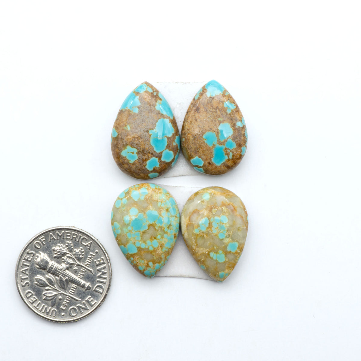 Number 8 Turquoise cabochons, blue and green color with brown matrix, polished stones on a white background, with a US dime for scale