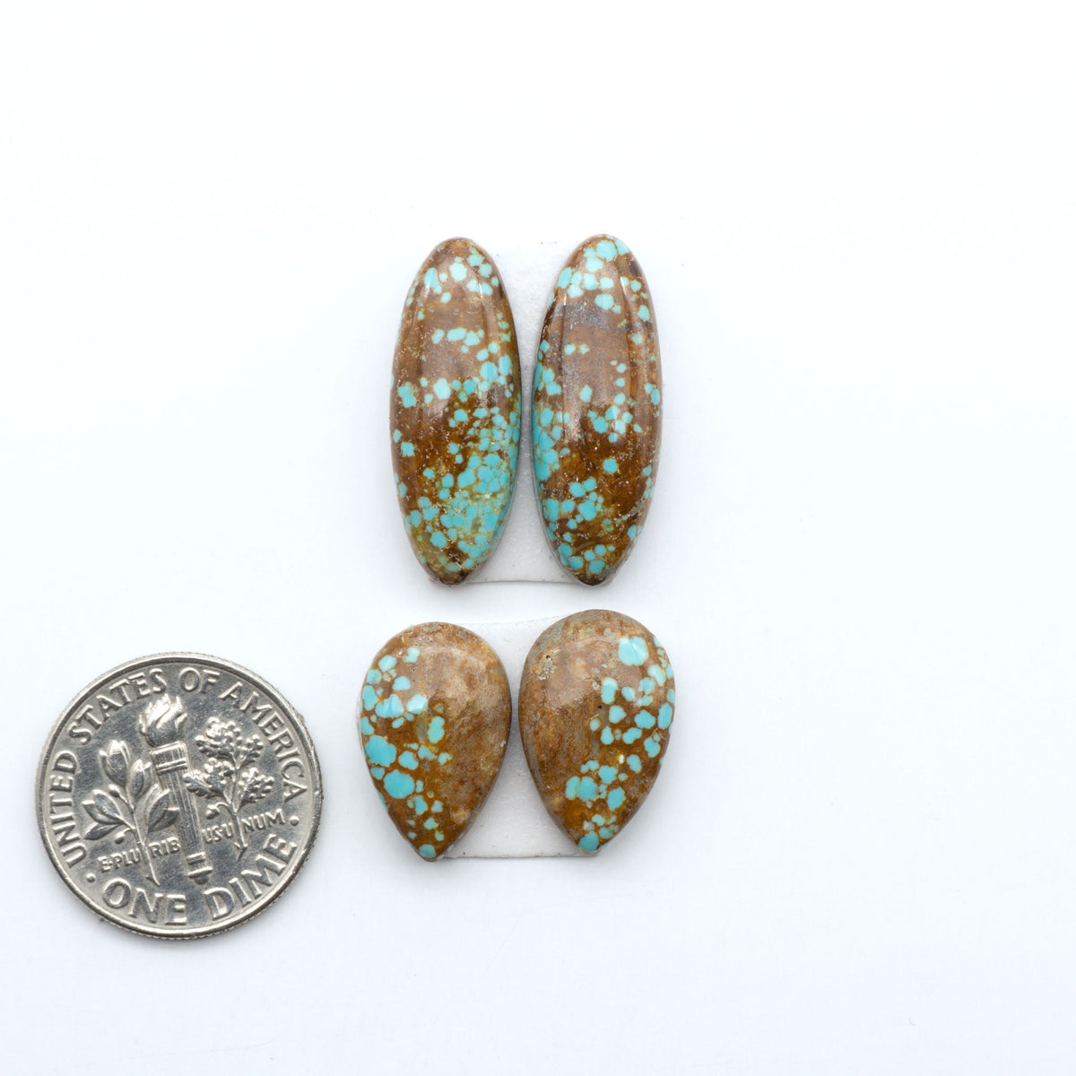 Number 8 Turquoise cabochons, blue and green color with brown matrix, polished stones on a white background, with a US dime for scale